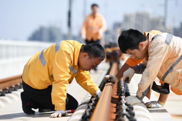 10月5日,中国铁路上海局集团有限公司合肥工务段的线路工钱程(前左)在