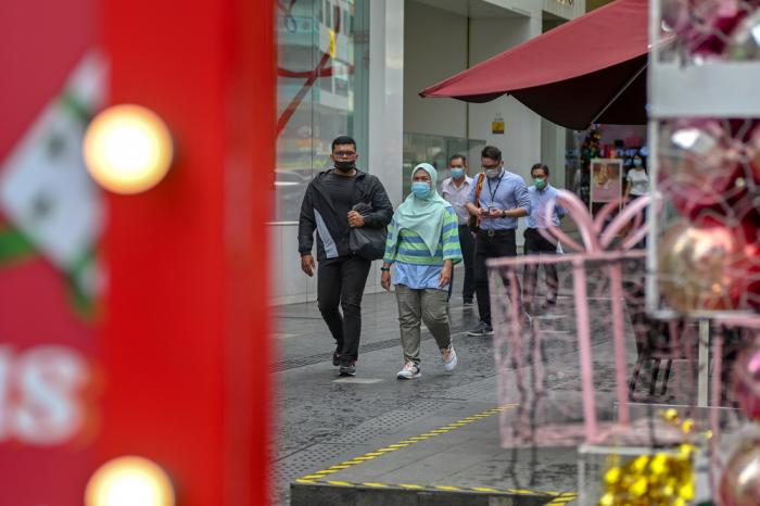 12月28日,人们戴着口罩走在马来西亚吉隆坡街头.